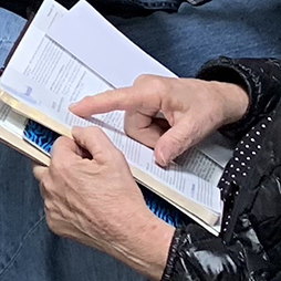 open bible index finger pointing to scripture in open bible